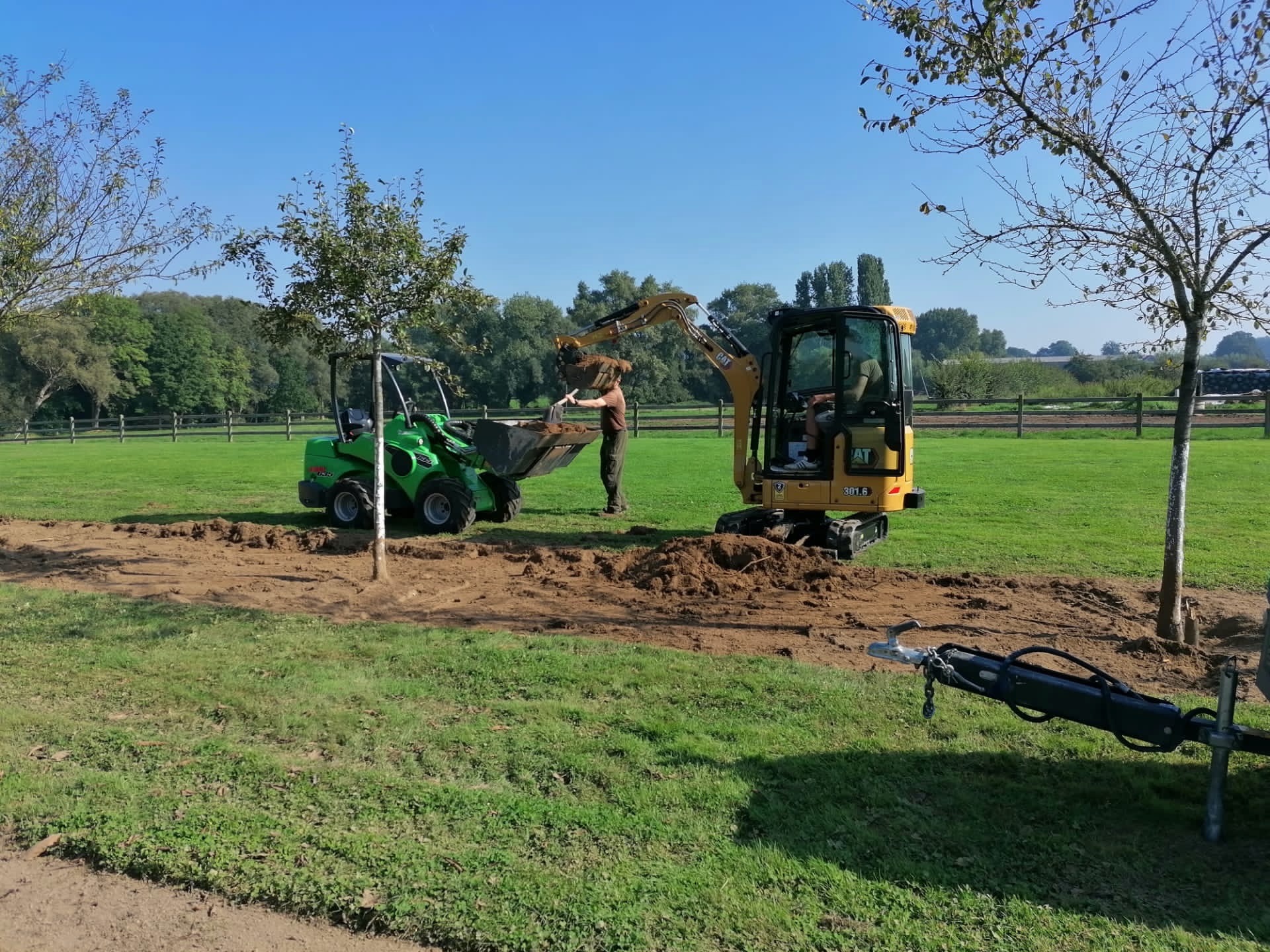 Bomen verplanten met minigraver op weiland